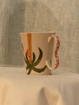 Wheel-thrown ceramic mug with wavy handle and Arabic calligraphy