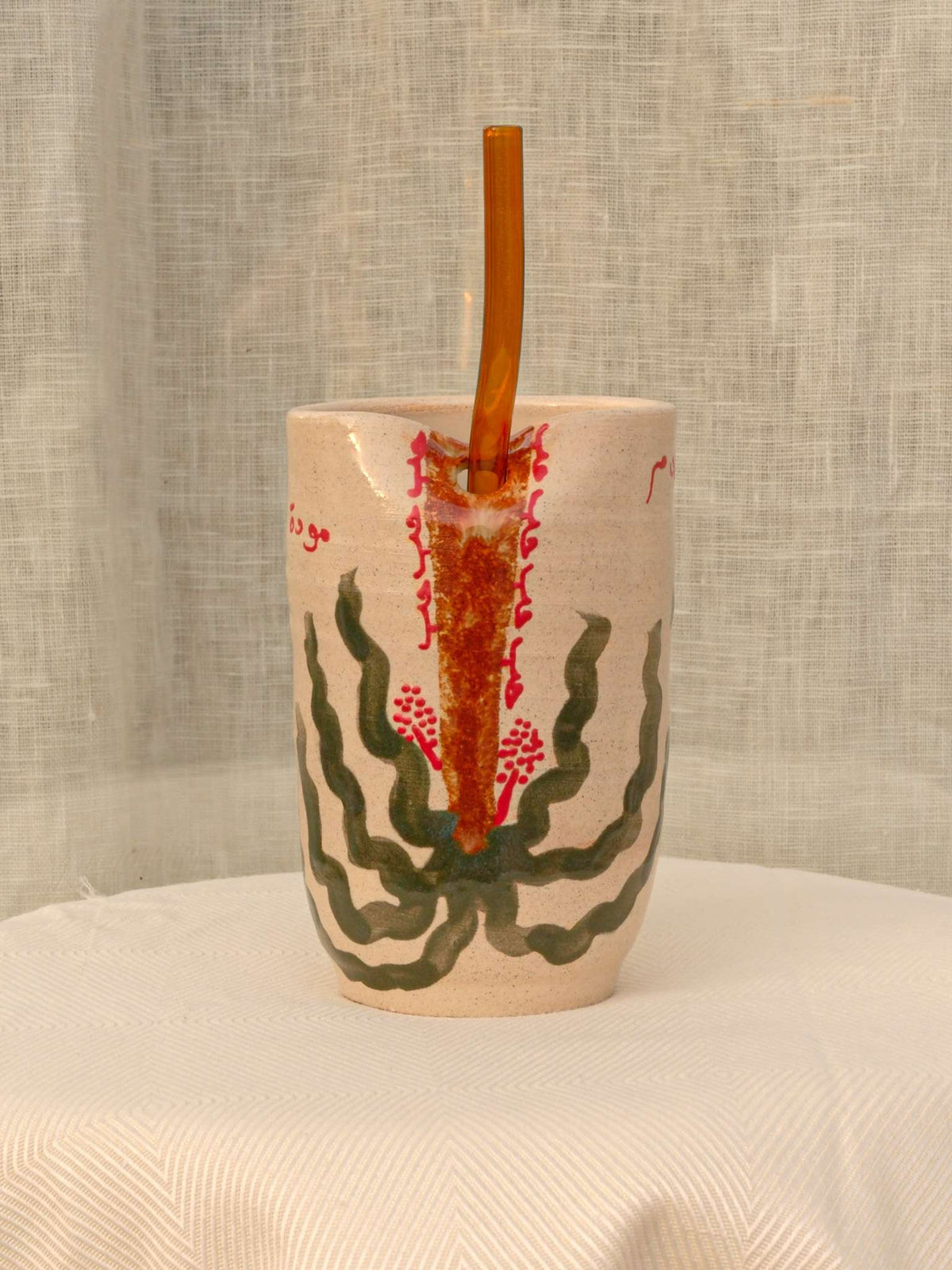Wheel-thrown ceramic tumbler with palm trees and Arabic calligraphy