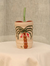 Wheel-thrown swirl ceramic tumbler with palm trees and a glass straw