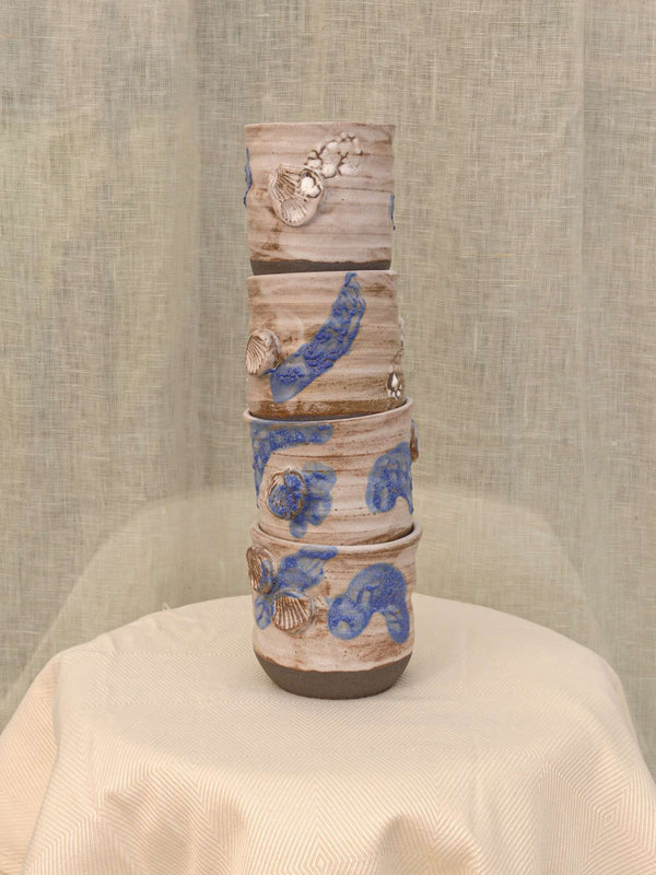 Set of two black clay cups with crawling glaze and seashell imprint