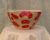 Large wheel-thrown salad bowl with red glaze strokes and undulated rim