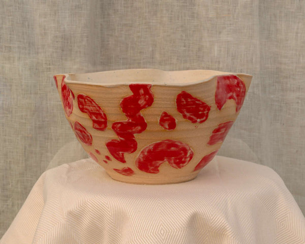 Large wheel-thrown salad bowl with red glaze strokes and undulated rim